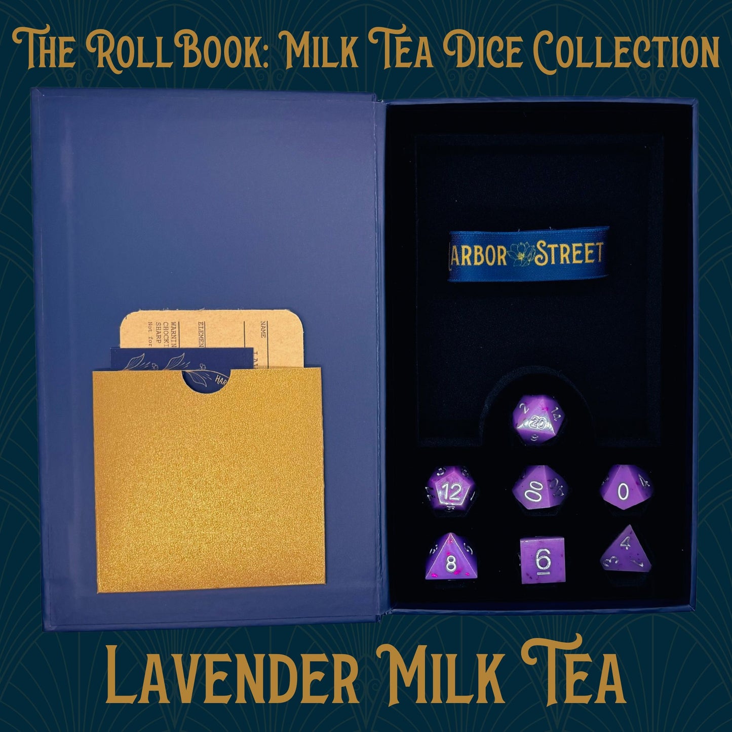 Blue book box with Lavender Milk Tea themed seven polyhedral dice collection. Blue elastic band with the Harbor Street logo. Gold paper pocket